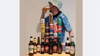 Gus Hully s steklenicami oz. pločevinkami piva iz 24 držav (JAMES WHITEMAN KORTOR/FACEBOOK)